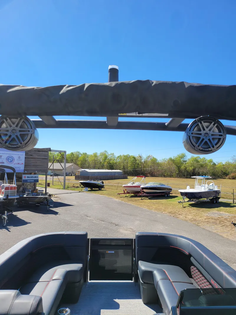 Slide: The Image of 2025 Quest M-22RLS LIMITED boat with speakers, parked outdoors under clear blue sky. - 5
