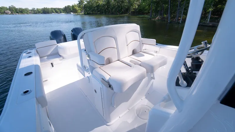 Slide: The Image of 2025 Sea Hunt Gamefish 27 Coffin Box boat interior with seating, on a serene lake. - 18