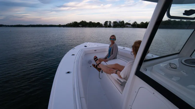 Slide: The Image of 2025 Sea Hunt Gamefish 27 Coffin Box boat with passengers enjoying a serene lake view. - 25