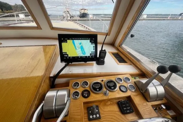 Slide: The Image of 1989 Duffy Wilbur 42 Flybridge Cruiser helm with navigation system and controls, docked by the water. - 12