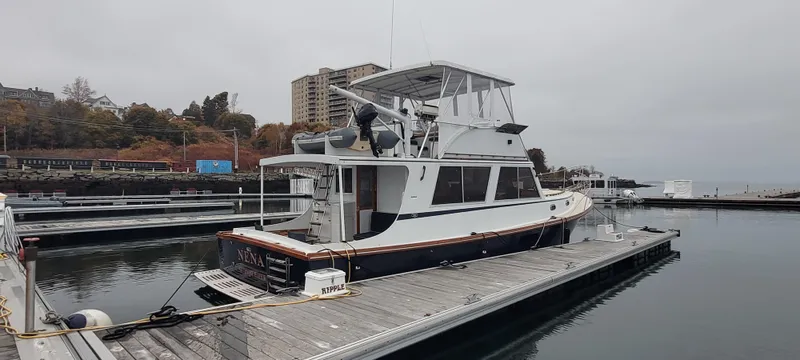 Slide: The Image of 1989 Duffy Wilbur 42 Flybridge Cruiser docked at marina on a cloudy day. - 2
