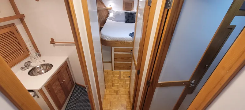 Slide: The Image of 1989 Duffy Wilbur 42 Flybridge Cruiser interior with bed, sink, and wooden cabinetry. - 28