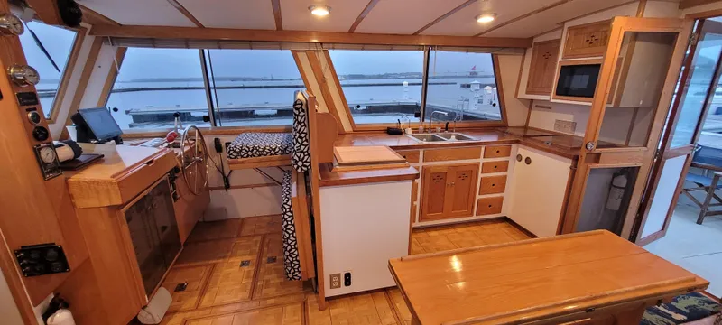 Slide: The Image of 1989 Duffy Wilbur 42 Flybridge Cruiser interior with wood finish, kitchen, and ocean view. - 5