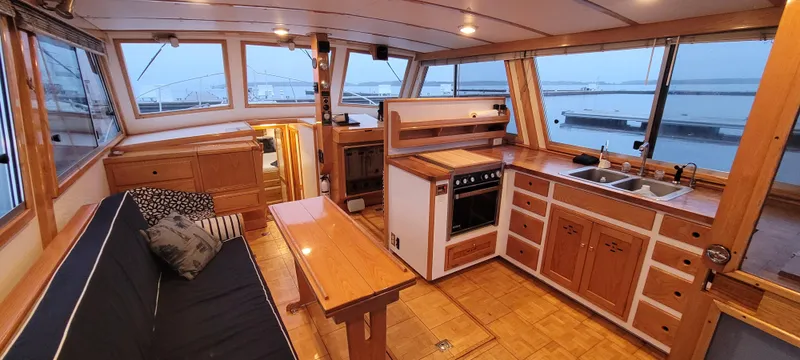 Slide: The Image of 1989 Duffy Wilbur 42 Flybridge Cruiser interior with wood finish, kitchen, and seating area. - 7