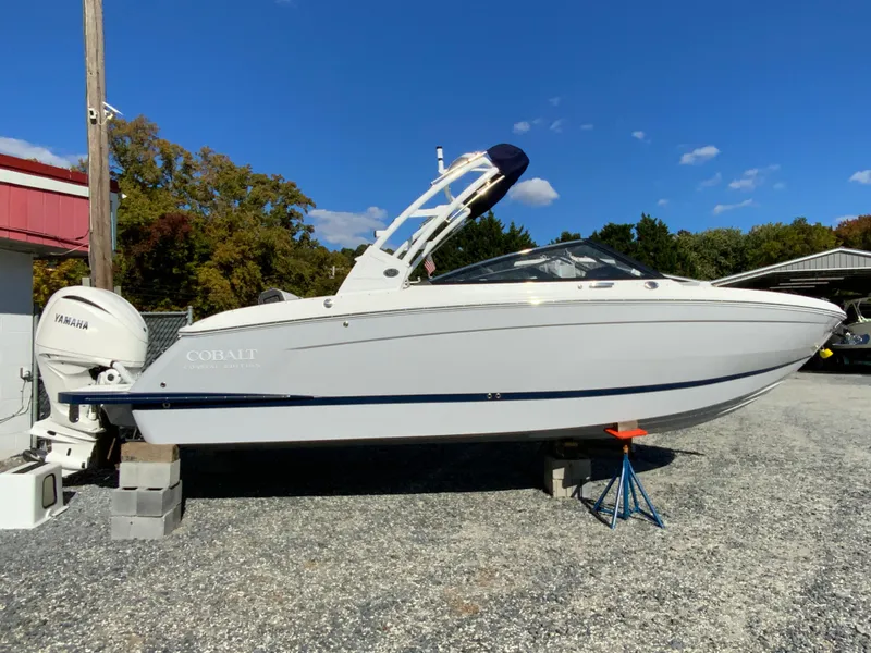 The Image of 2025 Cobalt R6 Outboard boat on display, white exterior, parked on gravel. - 1