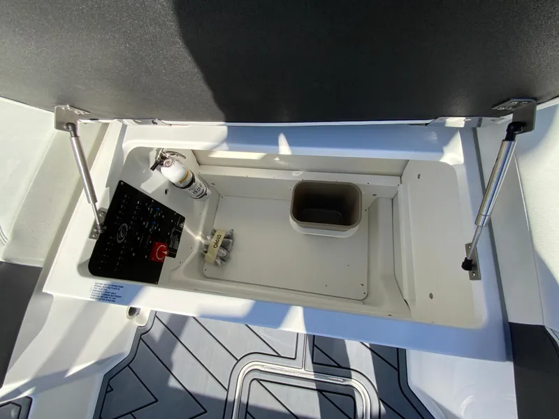 Slide: The Image of 2025 Cobalt R6 Outboard storage compartment with fire extinguisher and control panel. - 24
