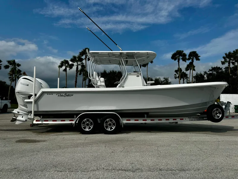 Slide: The Image of 2025 Pair Customs 27 Center Console boat on trailer, parked with palm trees in background. - 1