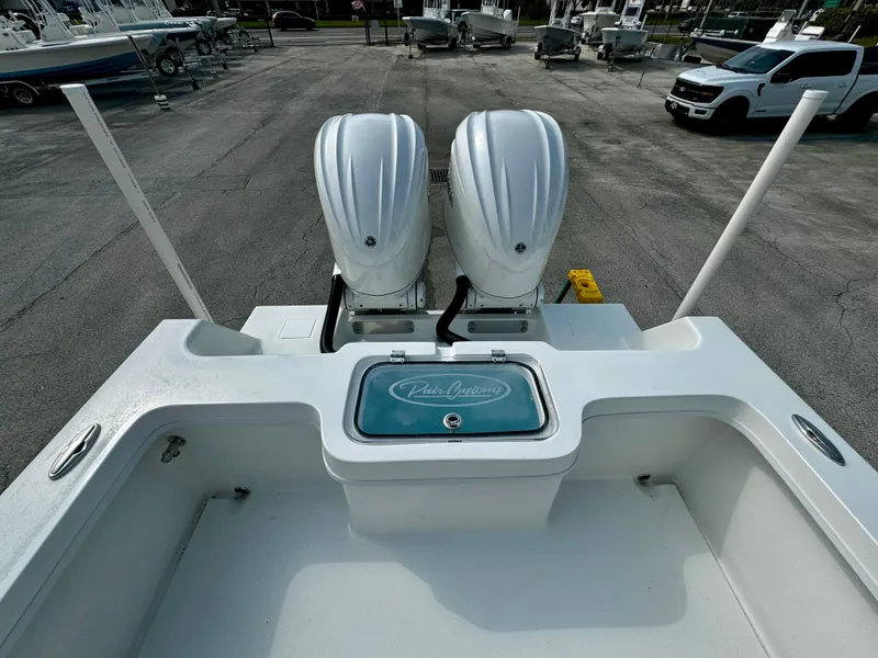 Slide: The Image of 2025 Pair Customs 27 Center Console boat with dual engines, docked in a marina. - 11