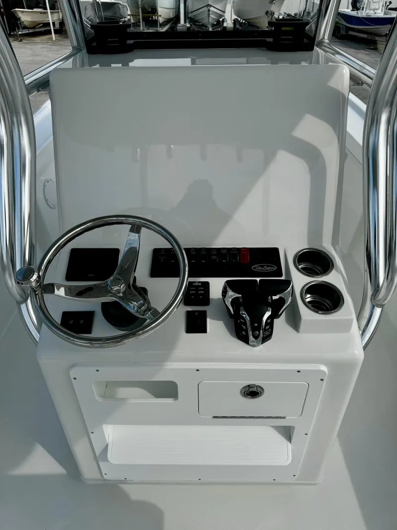 Slide: The Image of 2025 Pair Customs 27 Center Console boat dashboard with steering wheel and controls. - 14