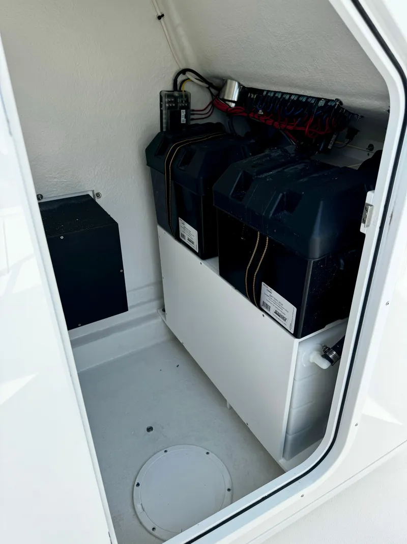 Slide: The Image of 2025 Pair Customs 27 Center Console battery compartment with dual batteries and wiring. - 16