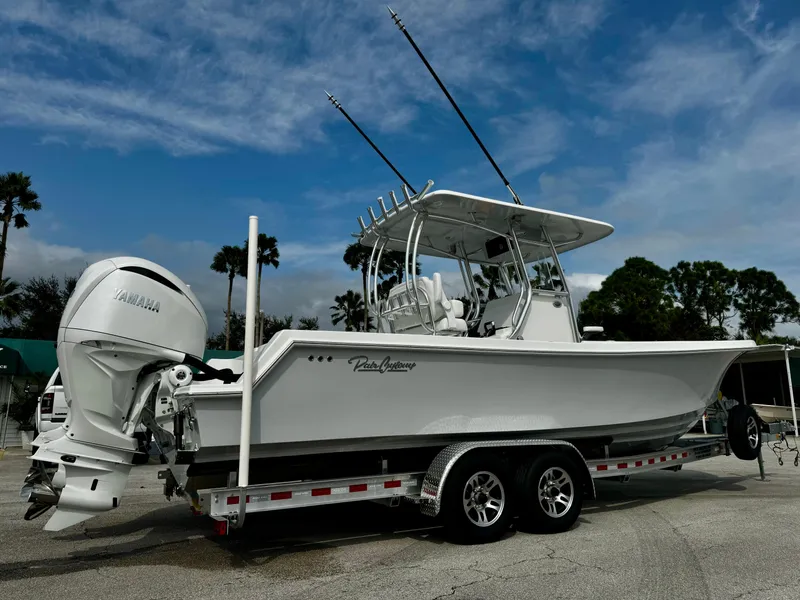 Slide: The Image of 2025 Pair Customs 27 Center Console boat on trailer, featuring Yamaha engine. - 2
