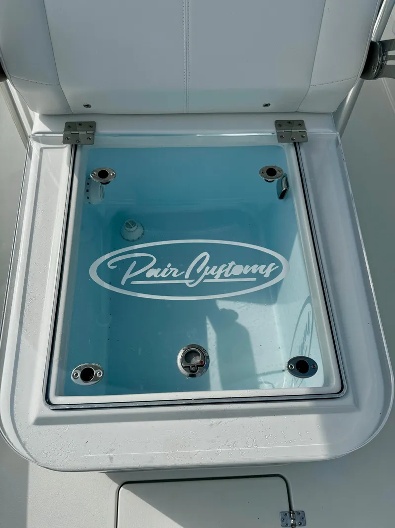 Slide: The Image of 2025 Pair Customs 27 Center Console livewell with logo, open lid view. - 20