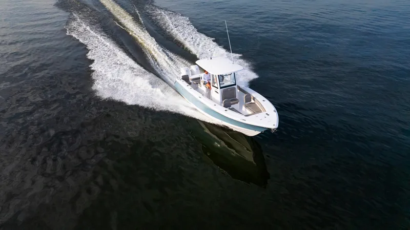 Slide: The Image of 2025 Sea Hunt Gamefish 27 boat cruising on open water, aerial view. - 6