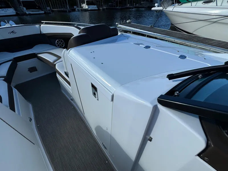 Slide: The Image of 2018 Monterey 328 Super Sport boat interior with seating and storage, docked by the water. - 24