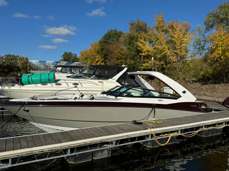 Slide: The Image of 2018 Monterey 328 Super Sport boat docked by autumn trees under blue sky. - 4