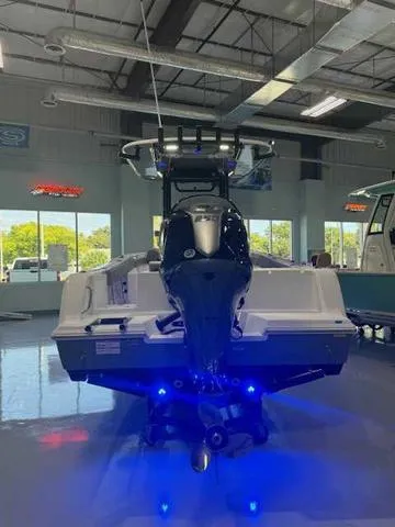 Slide: The Image of 2025 Sportsman Open 212 boat in showroom with blue LED lights. - 27