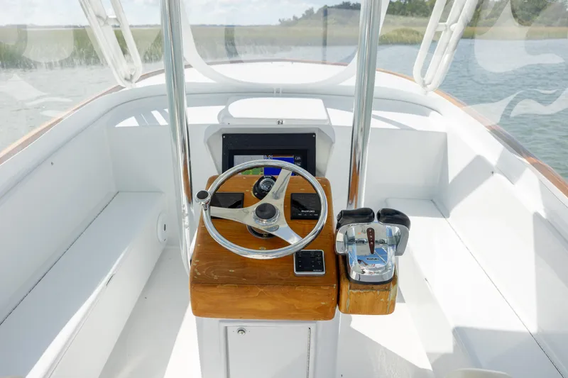 Slide: The Image of 2005 Custom Carolina 26 Tideline Boatworks Express helm with steering wheel and controls. - 12