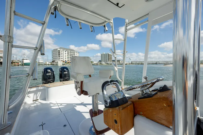 Slide: The Image of 2005 Custom Carolina 26 Tideline Boatworks Express on water, featuring helm and twin engines. - 15