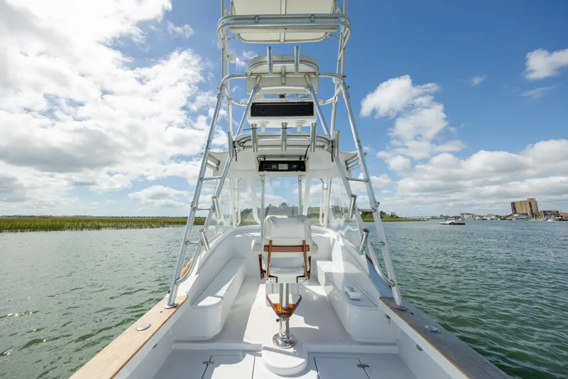 Slide: The Image of Custom Carolina 26 Tideline Boatworks Express 2005 on water, clear sky, spacious deck. - 9