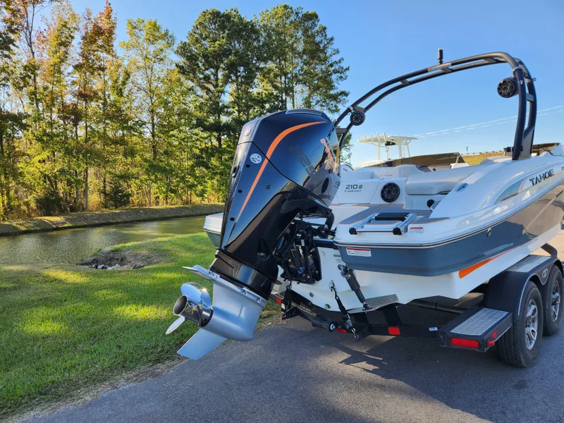 Slide: The Image of 2021 Tahoe 210 S boat on trailer by a scenic lake. - 3