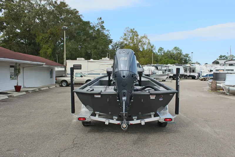 Slide: The Image of 2025 Avid 21 FSX boat on trailer, parked in lot with RVs and trees. - 7