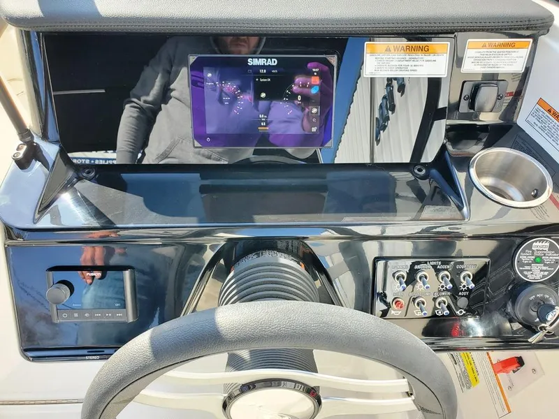 Slide: The Image of 2025 Sea Ray SPX 210 BR dashboard with Simrad display and controls. - 21