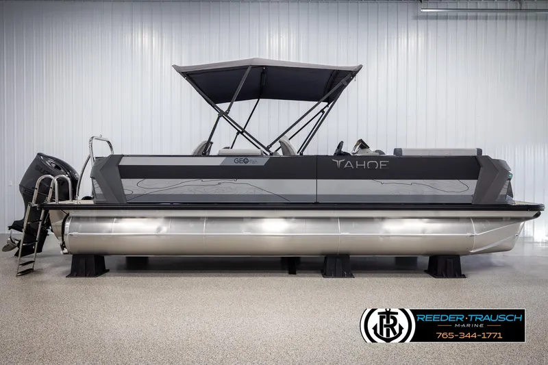 Slide: The Image of 2025 Tahoe TGO RF pontoon boat with canopy in showroom, Reeder-Trausch Marine logo visible. - 5