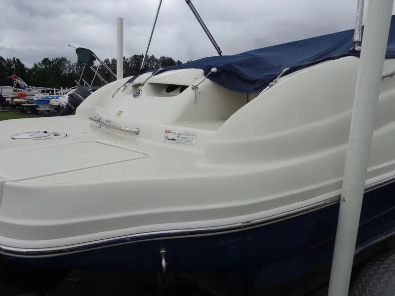 Slide: The Image of 2007 Sea Ray 200 Sundeck boat with blue cover, docked outdoors. - 10