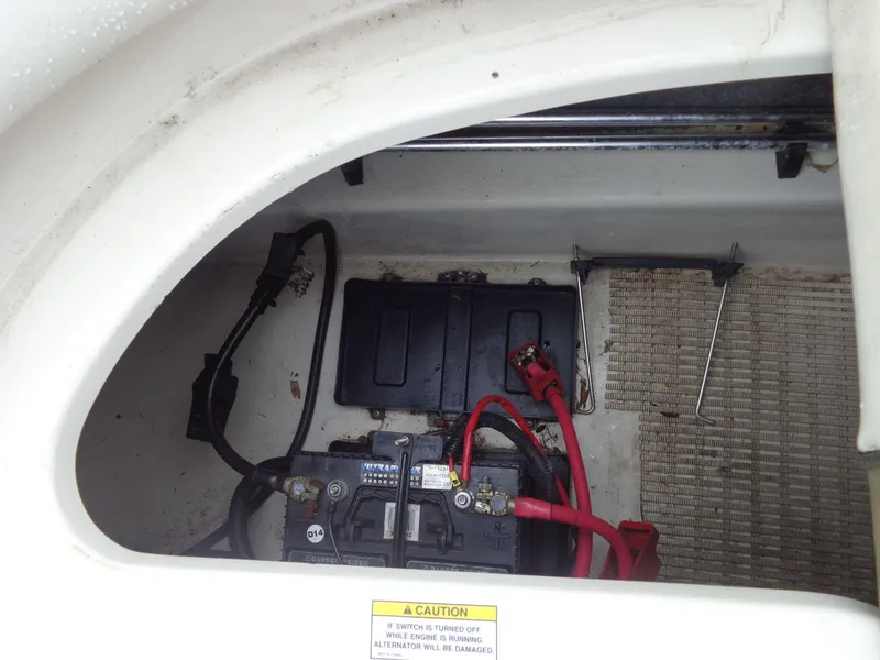Slide: The Image of 2007 Sea Ray 200 Sundeck battery compartment with cables and warning label. - 28