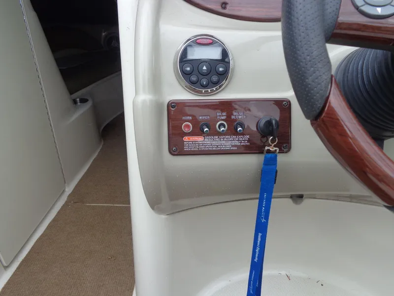 Slide: The Image of 2007 Sea Ray 200 Sundeck dashboard controls with steering wheel and key lanyard. - 37
