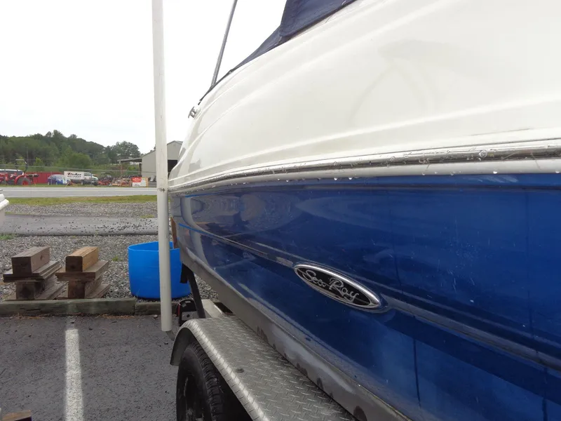 Slide: The Image of 2007 Sea Ray 200 Sundeck boat on trailer, blue and white exterior. - 7