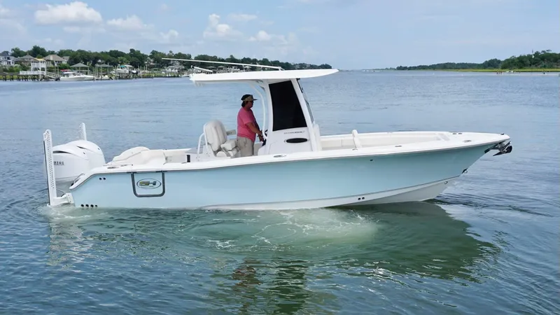 Slide: The Image of 2024 Sea Hunt Ultra 265 SE boat cruising on a calm waterway. - 1