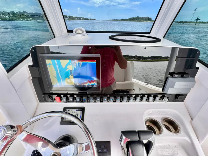 Slide: The Image of 2024 Sea Hunt Ultra 265 SE helm with navigation display and controls. - 10