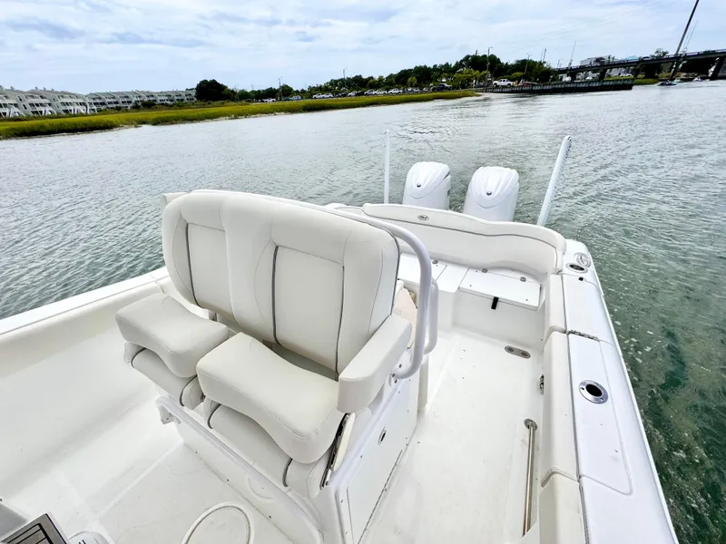 Slide: The Image of 2024 Sea Hunt Ultra 265 SE boat with dual engines on a calm waterway. - 8