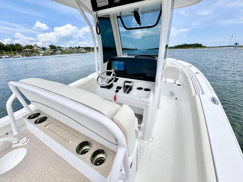 Slide: The Image of 2024 Sea Hunt Ultra 265 SE boat interior with helm, seating, and ocean view. - 9