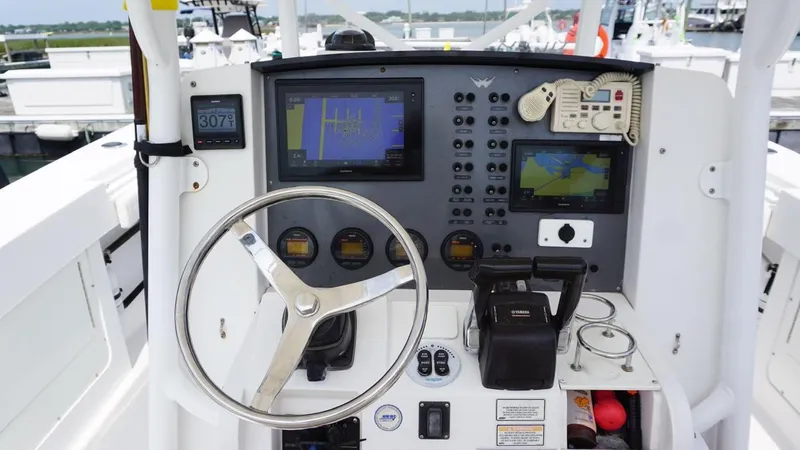 Slide: The Image of 2005 Southport 28 Center Console boat dashboard with navigation equipment and steering wheel. - 9