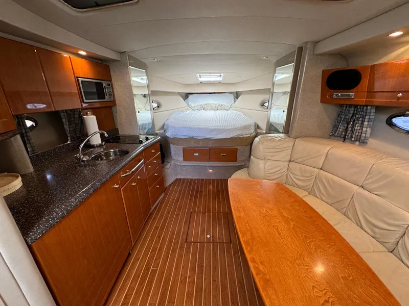 Slide: The Image of 2004 Formula 37 Performance Cruiser interior with kitchen, seating, and bed. Luxurious wood finish. - 18
