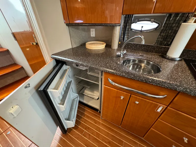 Slide: The Image of 2004 Formula 37 Performance Cruiser kitchen with open fridge, sink, and wooden cabinetry. - 20