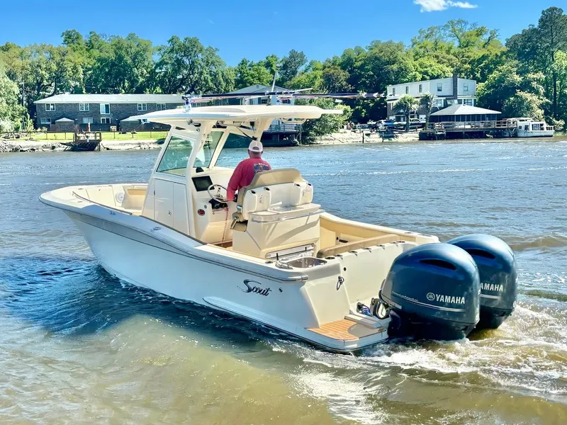 Slide: The Image of 2019 Scout 255 LXF boat with dual Yamaha engines cruising on a sunny day. - 2