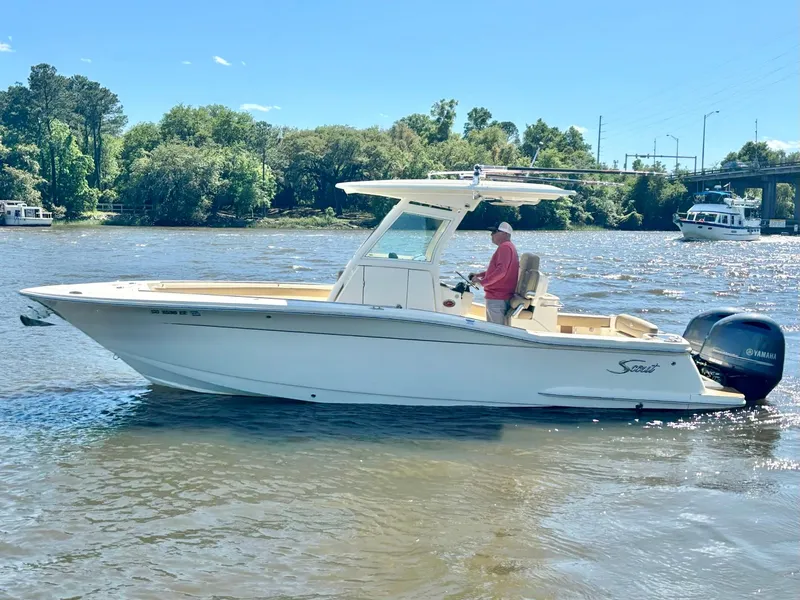 Slide: The Image of 2019 Scout 255 LXF boat cruising on a sunny river. - 5