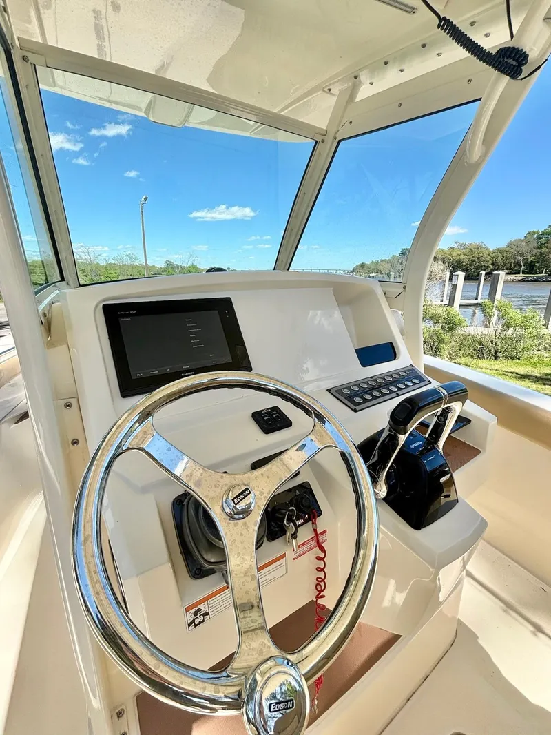 Slide: The Image of 2019 Scout 255 LXF boat helm with steering wheel and control panel. - 6