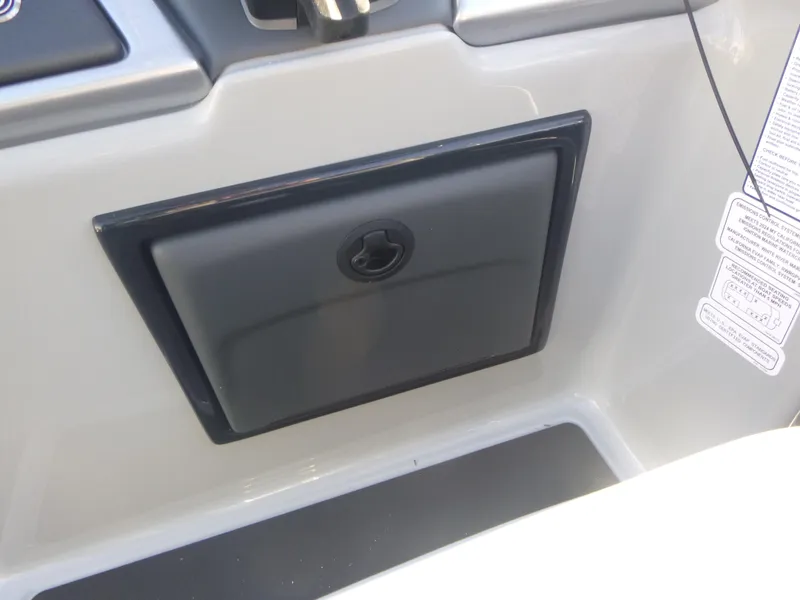 Slide: The Image of 2024 Ranger Reata 223C boat storage compartment with sleek black cover. - 16