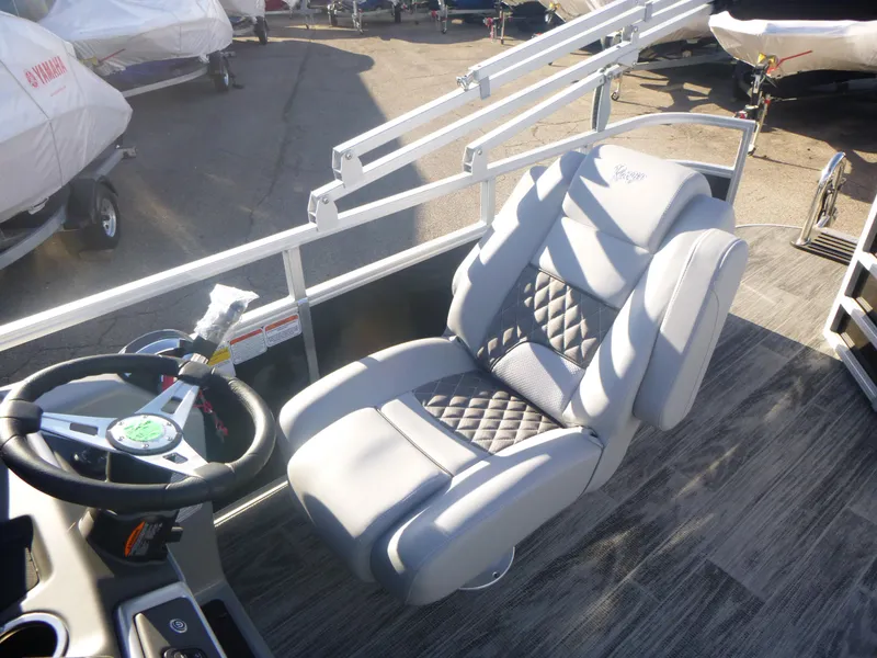 Slide: The Image of 2024 Ranger Reata 223C boat interior with luxury captain's chair and steering wheel. - 18