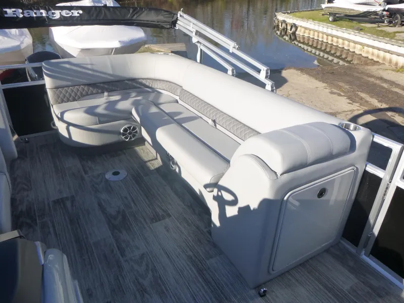 Slide: The Image of 2024 Ranger Reata 223C boat interior with gray seating and wood-style flooring. - 19