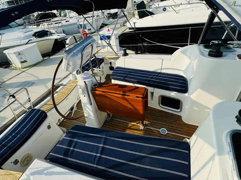 Slide: The Image of 2007 Jeanneau Sun Odyssey 36i yacht cockpit with striped seating and wooden flooring. - 16