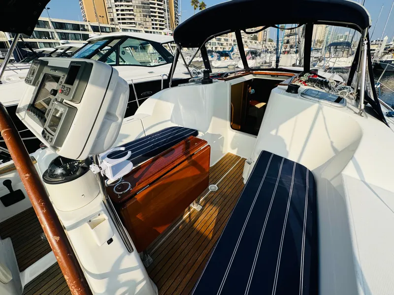 Slide: The Image of 2007 Jeanneau Sun Odyssey 36i cockpit with navigation equipment and seating in a marina. - 19