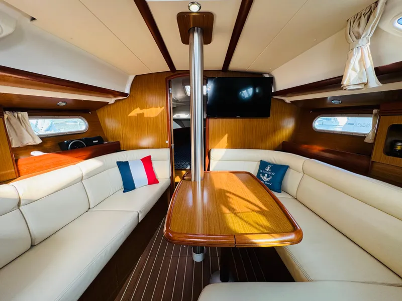 Slide: The Image of Interior of 2007 Jeanneau Sun Odyssey 36i sailboat with cozy seating and wooden table. - 34