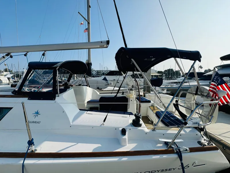 Slide: The Image of 2007 Jeanneau Sun Odyssey 36i sailboat docked at marina, featuring sleek design and American flag. - 4