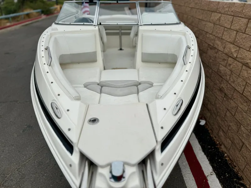 Slide: The Image of 2006 Larson LXi 248 boat interior with white seating and windshield. - 10