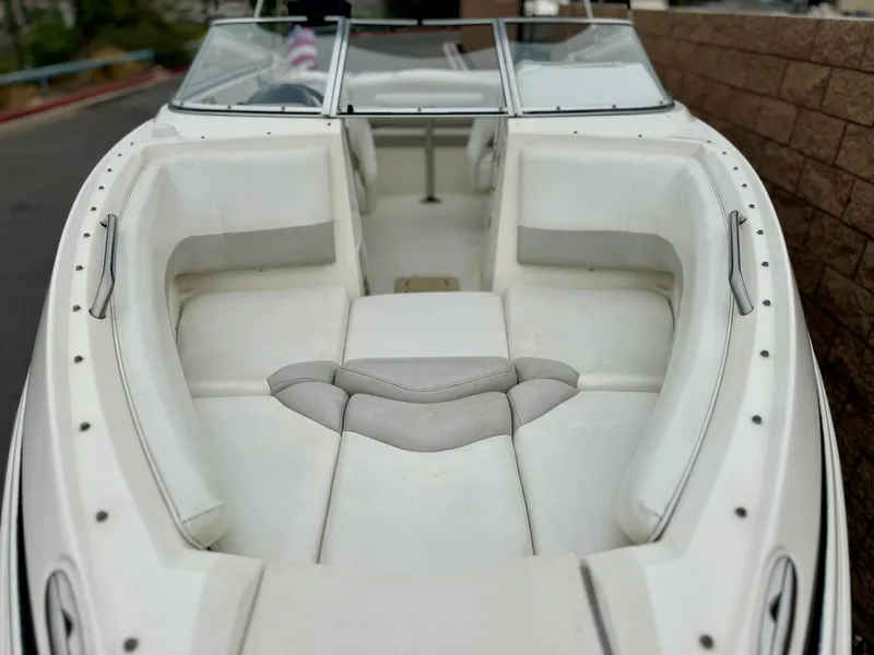 Slide: The Image of 2006 Larson LXi 248 boat interior with white seating and cup holders. - 11